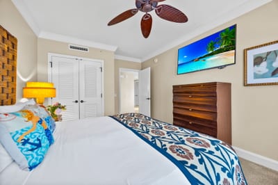 Primary bedroom features a plush King bed, 55" Smart TV, and peaceful garden views.