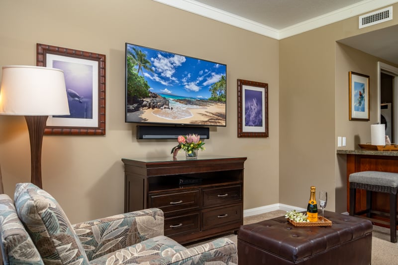 Cozy seating area with Smart TV and tropical artwork, ideal for evening downtime.