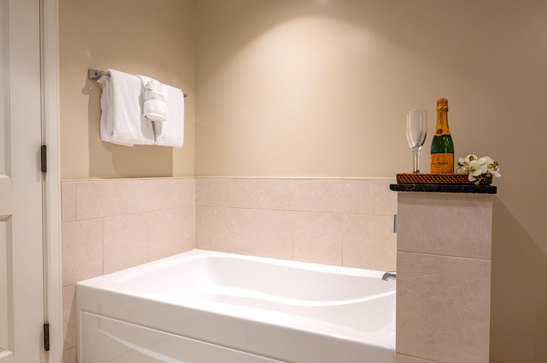 Separate soaking tub with sleek granite counters brings a luxe feel to your ensuite bath.