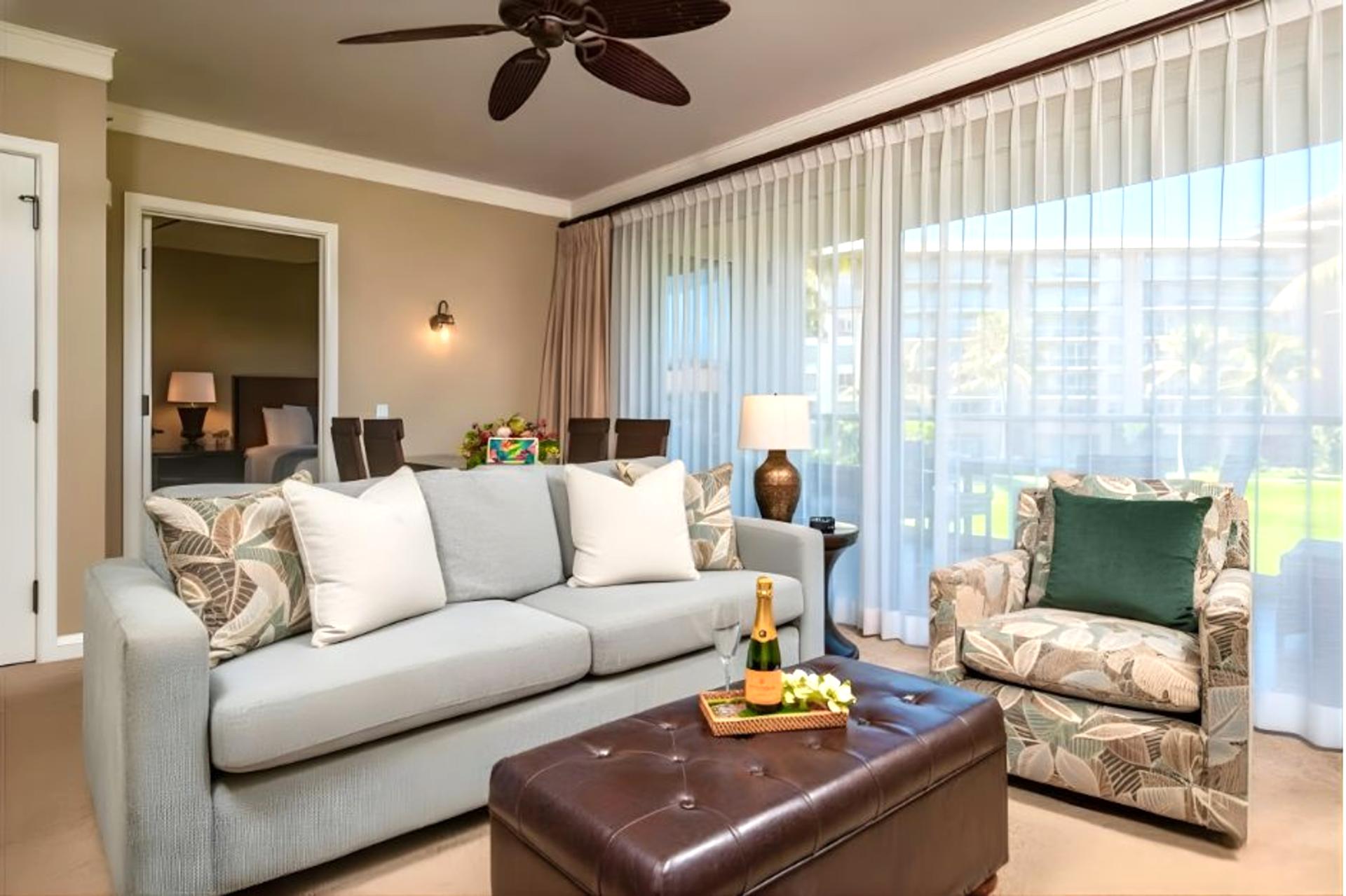 Lounge in comfort with a large sectional and ceiling fan, steps from the lanai and natural light.