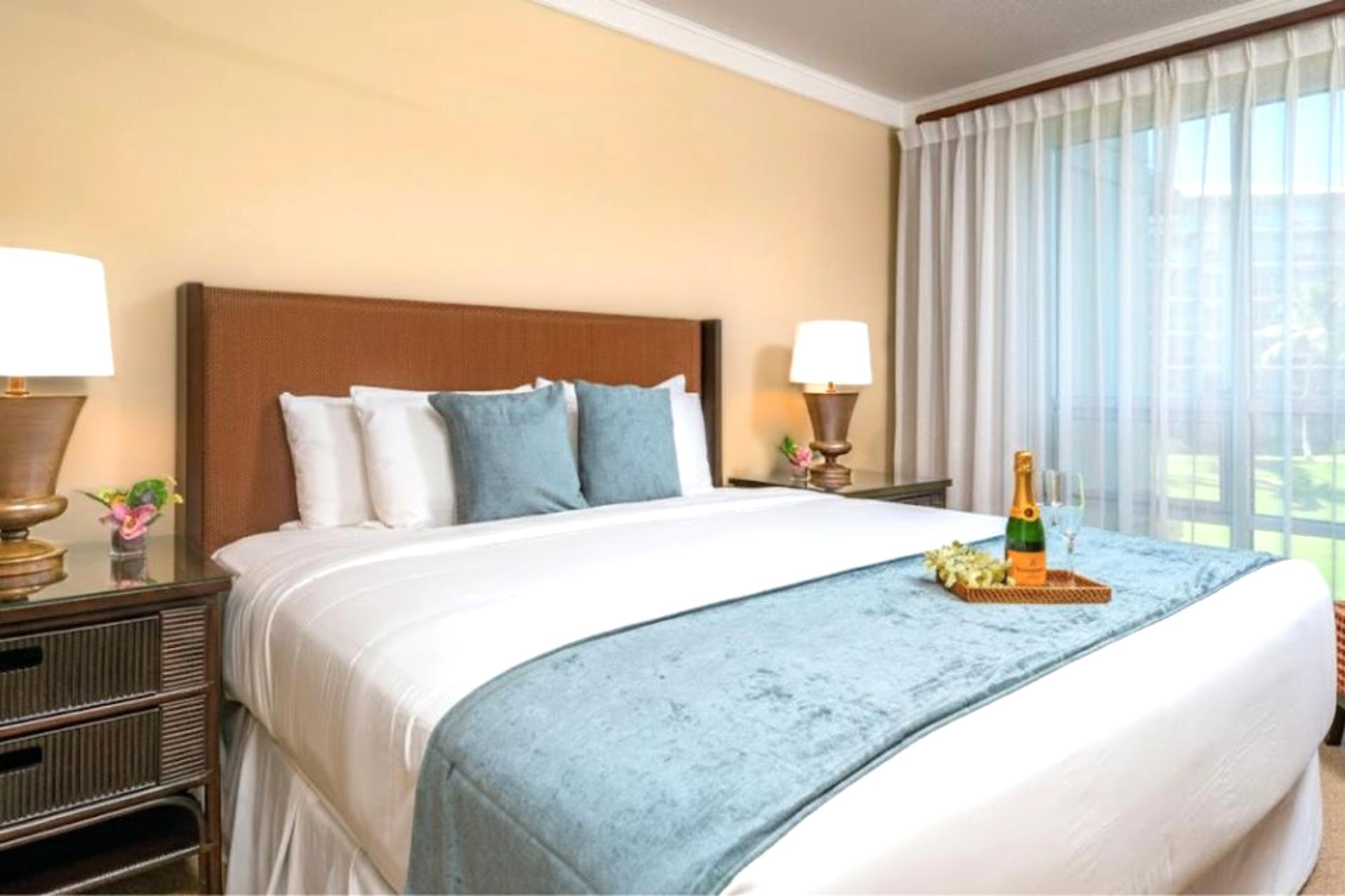 Primary bedroom with King bed and lanai access, plus soft natural light and tropical views.