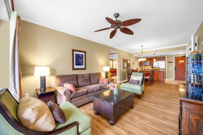 Gather in the open living area with warm wood tones, ample seating, and direct access to outdoor space.