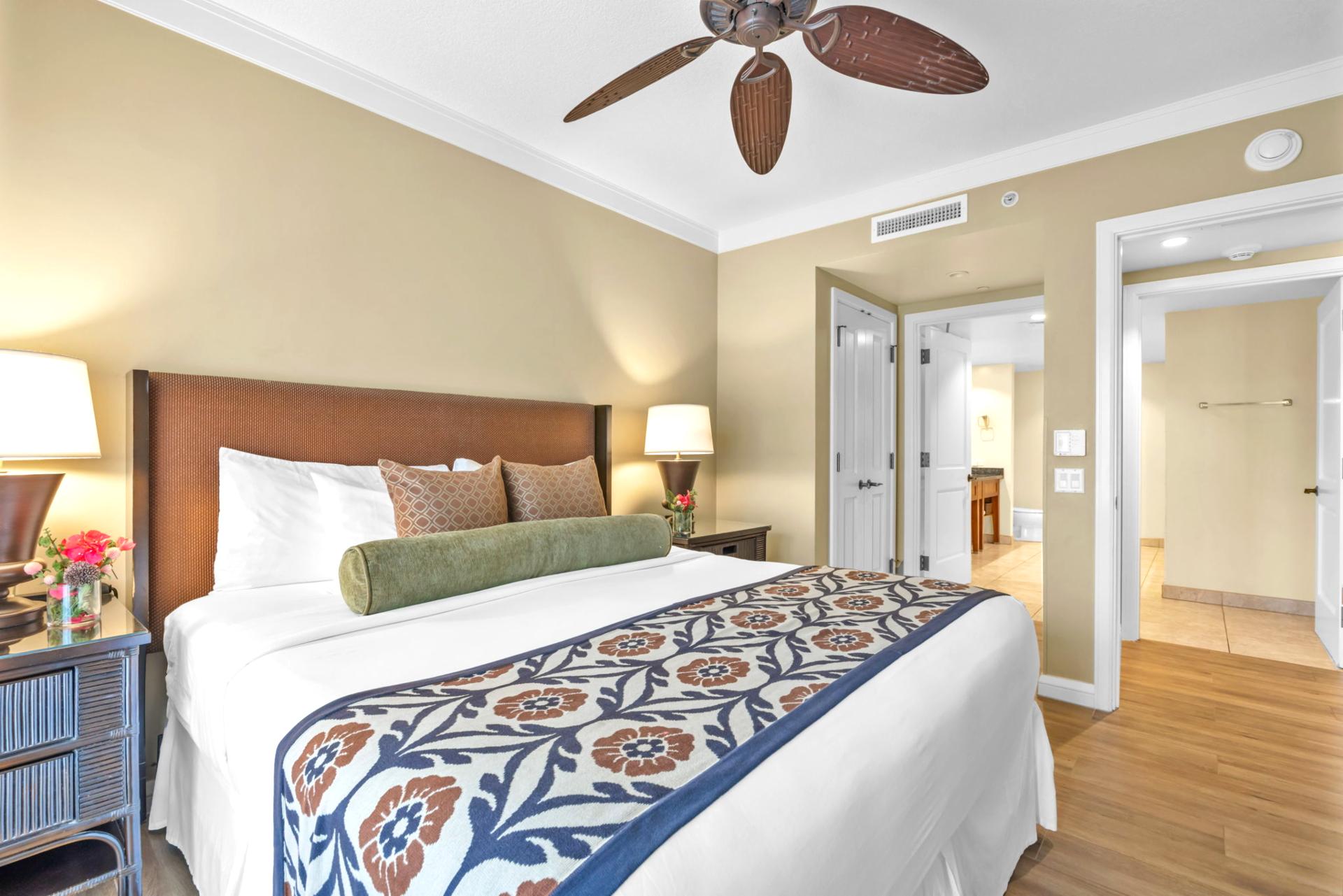 Your primary suite opens to the lanai and features resort views, a King bed, and soothing neutral tones.