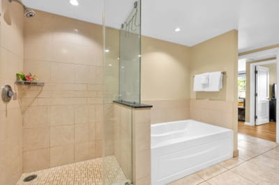 The en suite bath includes a granite vanity and walk-in shower with glass door for a refreshing daily routine.