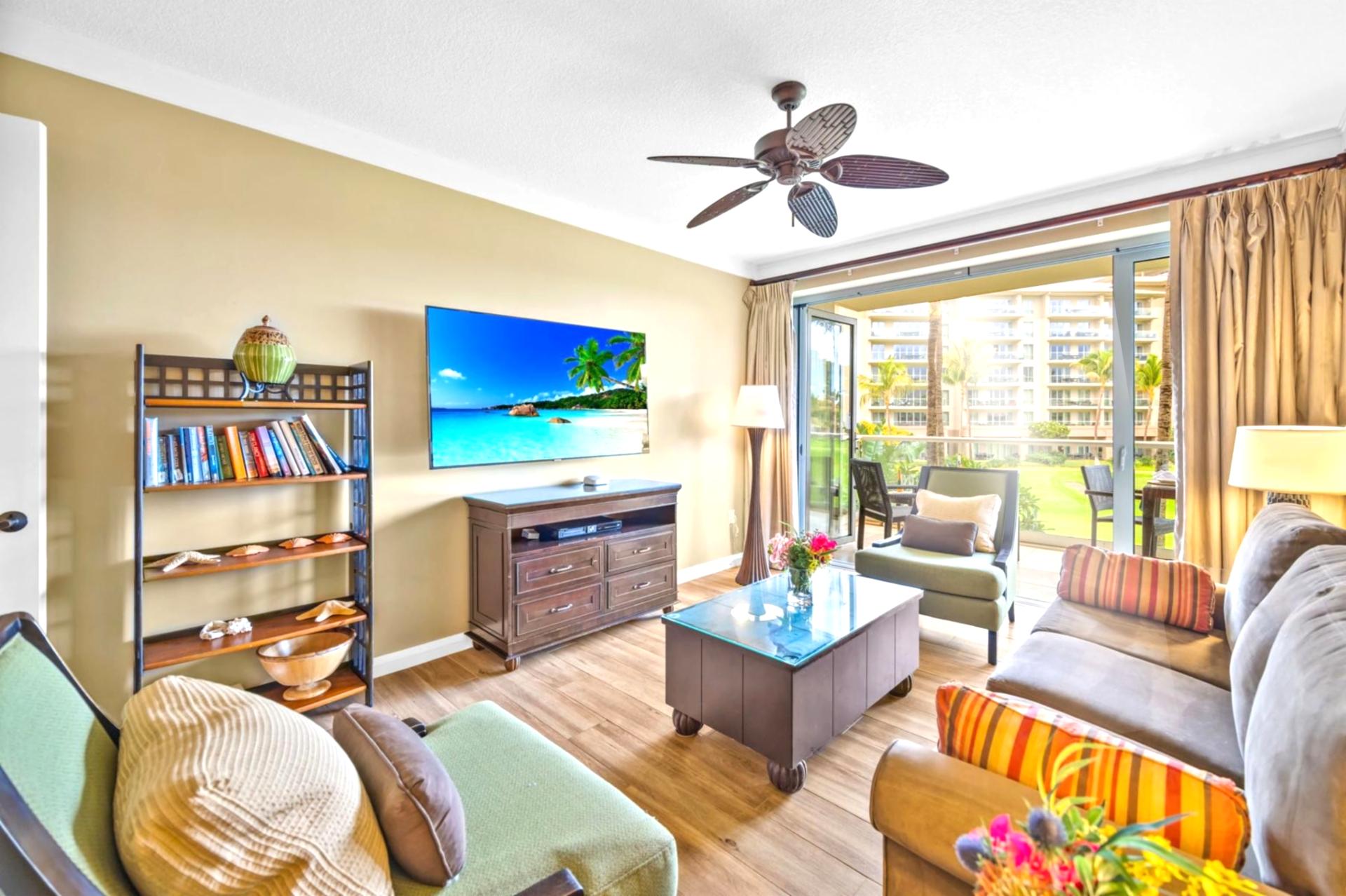 Enjoy casual downtime or a movie on the Smart TV from your spacious living room with ceiling fan and island-style decor.