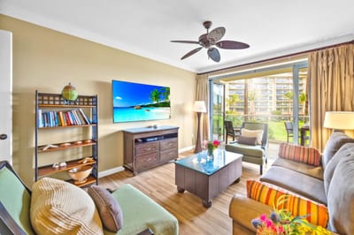 Enjoy casual downtime or a movie on the Smart TV from your spacious living room with ceiling fan and island-style decor.