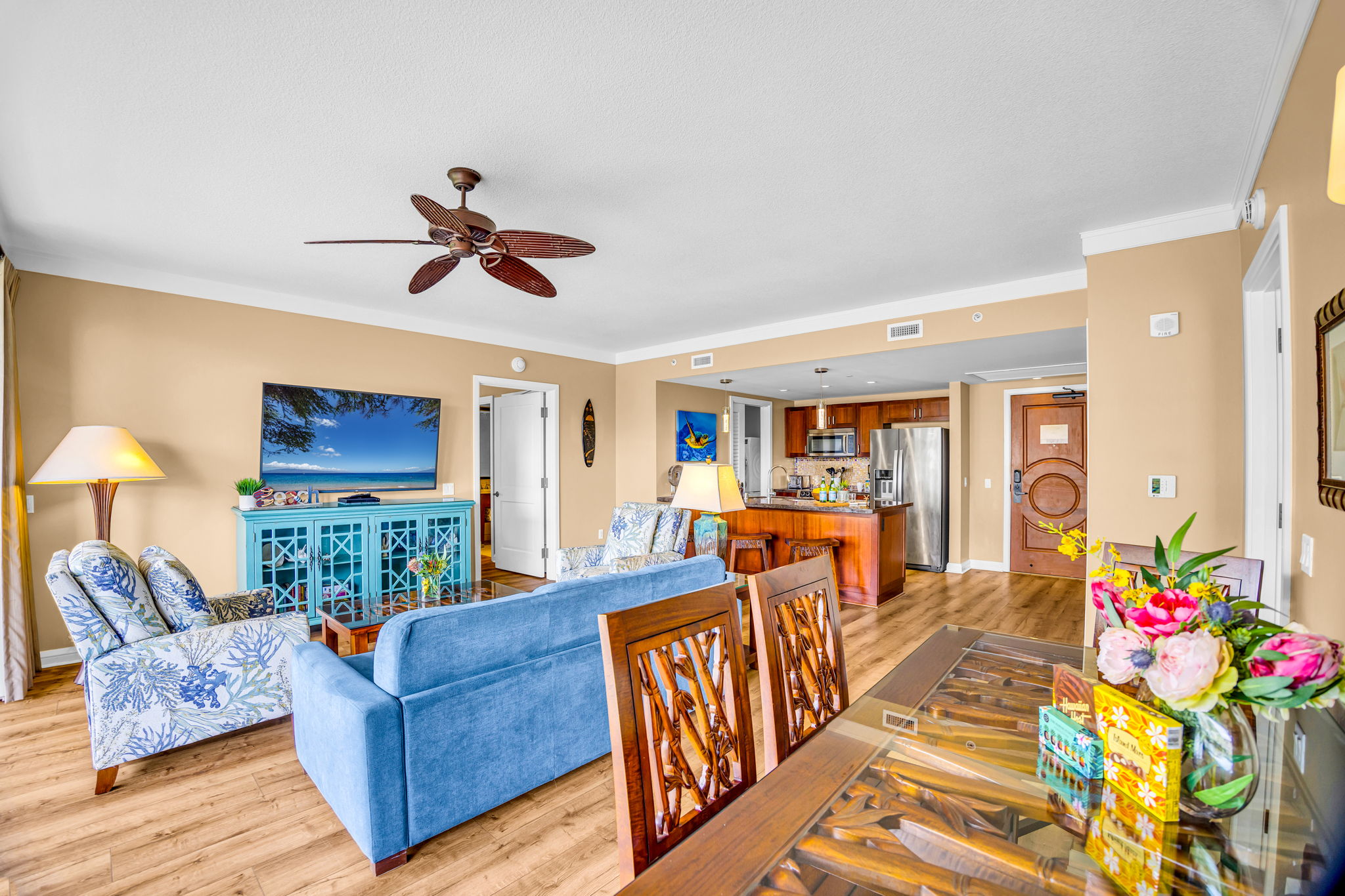 Living room with a large sofa, two comfy chairs, ceiling fan, and direct access to the lanai for a breezy, connected layout. HKH-305