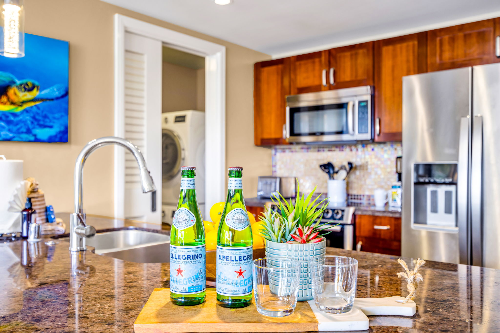 Granite island with prep sink and stainless steel appliances in a fully equipped kitchen made for home-cooked meals. HKH-305