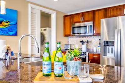 Granite island with prep sink and stainless steel appliances in a fully equipped kitchen made for home-cooked meals. HKH-305