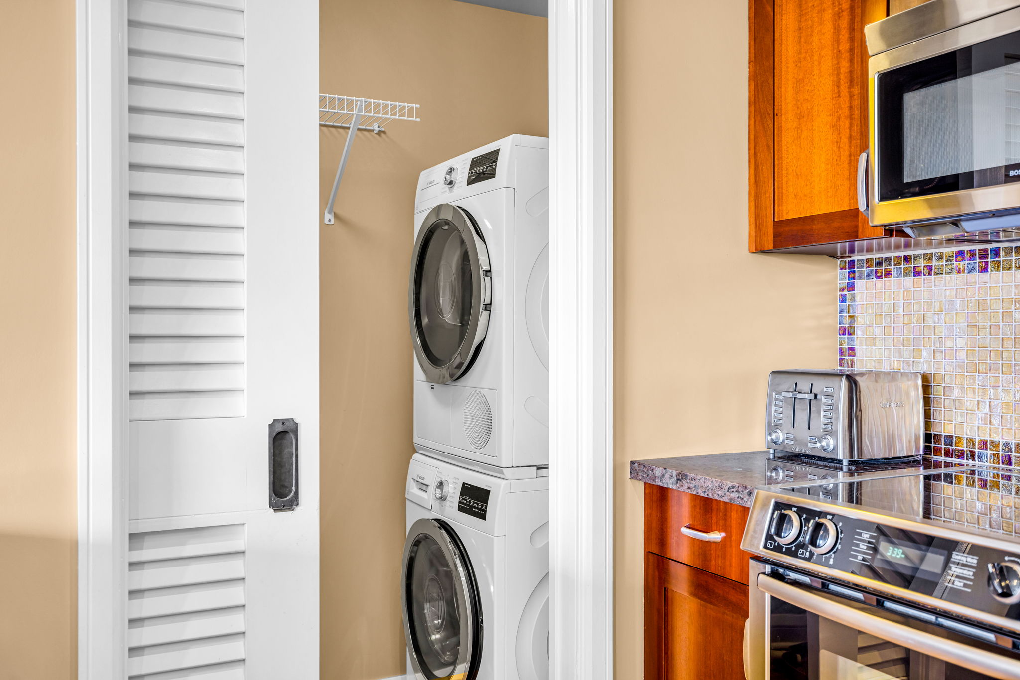 In-unit washer and dryer tucked neatly near the kitchen for easy mid-stay refreshes. HKH-305