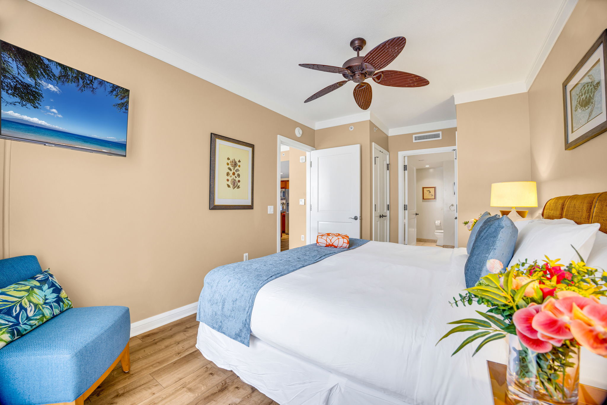 Bright primary bedroom with King bed, tropical artwork, and direct access to the ensuite bath. HKH-305