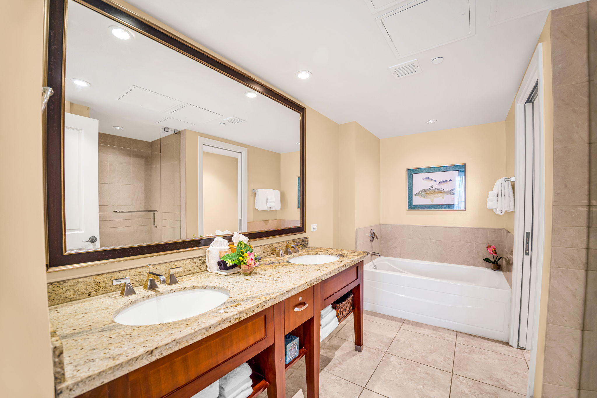 Granite double vanity and full-size tub in a spacious guest bathroom with thoughtful finishes.