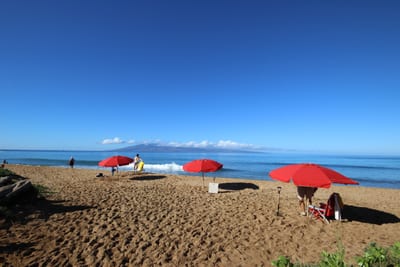 Steps from the sand—enjoy calm waters, red umbrellas, and postcard-worthy views at Kaanapali Beach