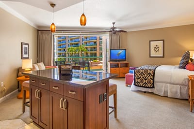 Modern kitchen with granite countertops, pendant lighting, stainless appliances, and bar seating for four