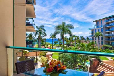Spectacular resort view with winding pools, palm trees, and turquoise ocean just beyond your private lanai