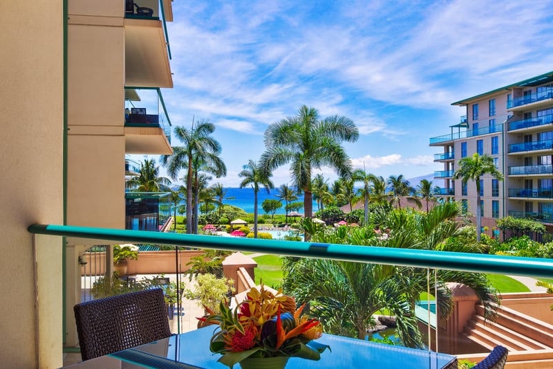 Spectacular resort view with winding pools, palm trees, and turquoise ocean just beyond your private lanai