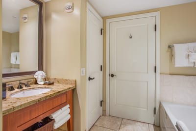Spacious bathroom with soaking tub, granite vanity, and soft neutral tones for a calming retreat