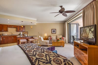 Elegant island bedroom with king bed, bench, and ceiling fan—perfect for cool, restful nights in paradise