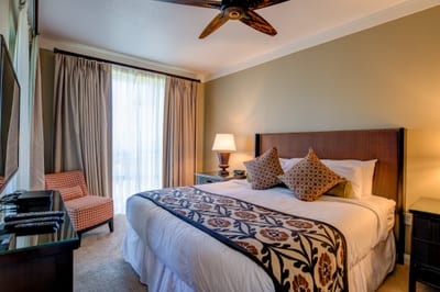Wake up to paradise in a premium suite with balcony dining, plush bedding, and tropical garden views. HKH-338