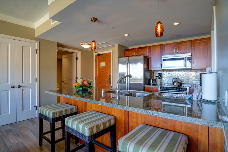 Chef-ready kitchen with granite counters, top appliances, and cozy bar stools—luxury meets island ease