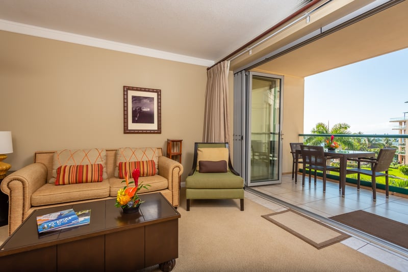 Stylish living space with warm tones, tropical floral, and seamless transition to your private Maui balcony