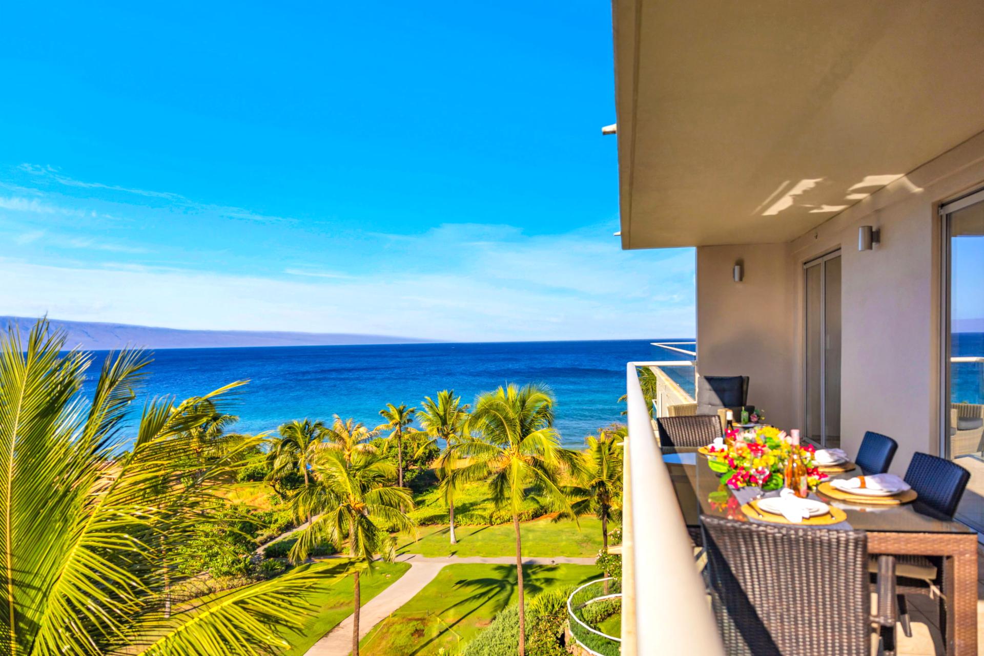 Lounge on the private lanai with sweeping blue-water views framed by tropical greenery.