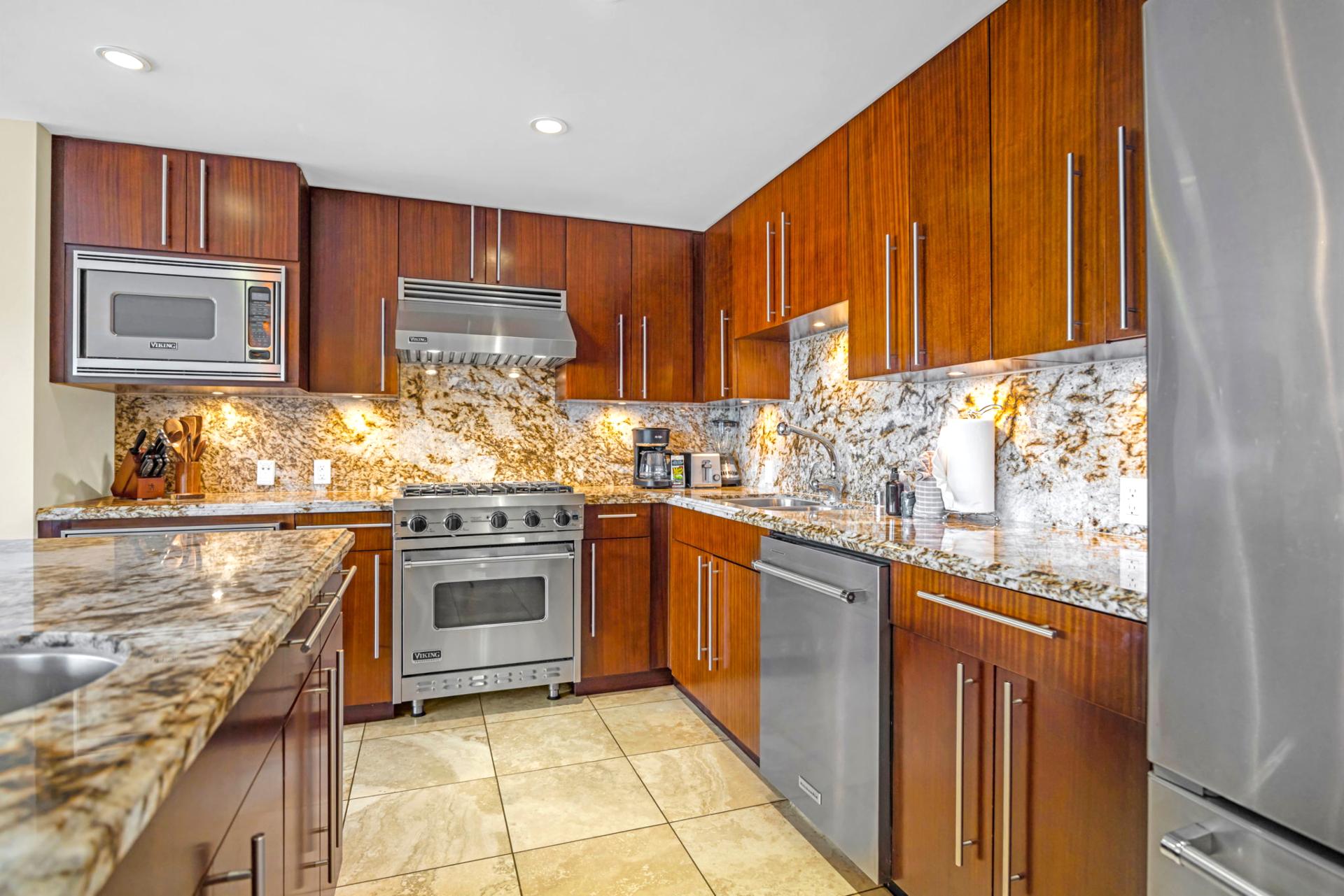 Kitchen detail shot highlights stainless appliances and stone finishes with practical design.