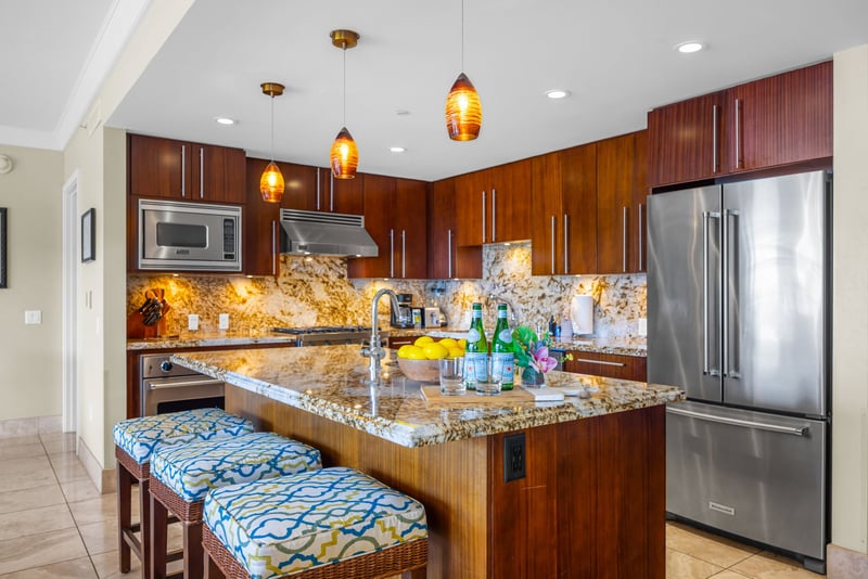 Fully equipped kitchen with stainless steel appliances and island bar for added prep space.