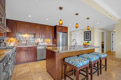Spacious kitchen with granite counters, full-size appliances, and breakfast bar seating for casual bites. HKH-504