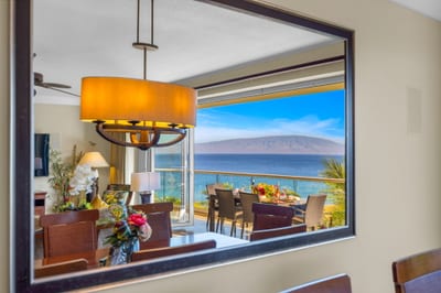 Dining area with classic wood finishes and ocean view through the sliding glass doors. HKH-504