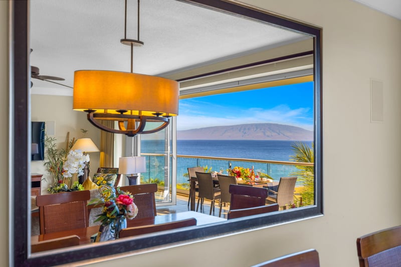 Dining area with classic wood finishes and ocean view through the sliding glass doors.