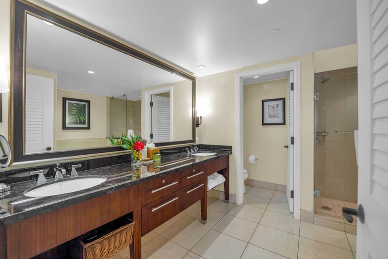 Walk-in shower with tile surround in the attached guest bathroom.
