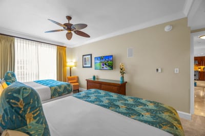 Guest bedroom with two King beds, ceiling fan, and tasteful island-inspired decor. HKH-504