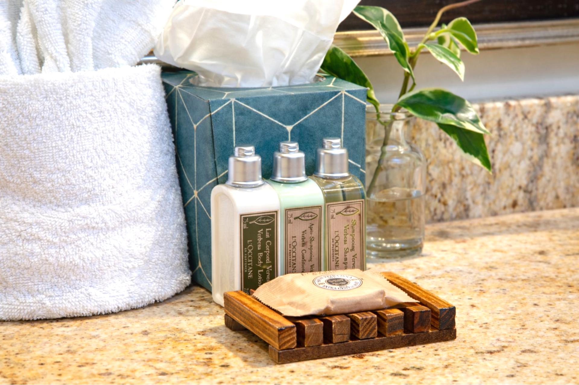 Complimentary L'Occitane bath amenities rest on the granite countertop, adding a luxurious touch to your daily routine during your stay.