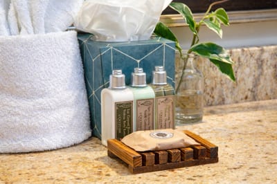 Complimentary L'Occitane bath amenities rest on the granite countertop, adding a luxurious touch to your daily routine during your stay. HKH-515