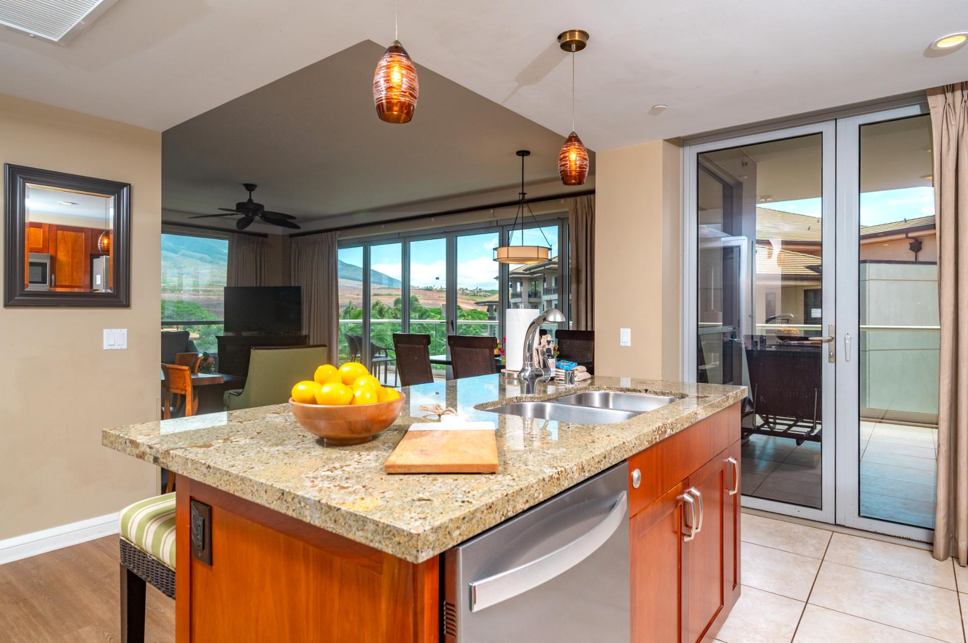 Prep meals or pour a drink at the granite kitchen island with views stretching from your living area out to the lanai and mountains beyond.