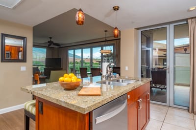 Prep meals or pour a drink at the granite kitchen island with views stretching from your living area out to the lanai and mountains beyond. HKH-520
