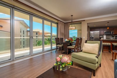 Natural light pours into the open living and dining area through full-length glass doors, inviting you to step out to the wraparound lanai. HKH-520