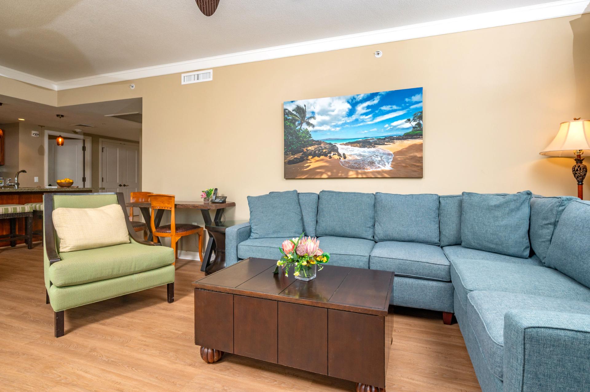 The living area offers plenty of seating for your group, with a large sectional, accent chair, and convenient desk for work or planning island adventures.