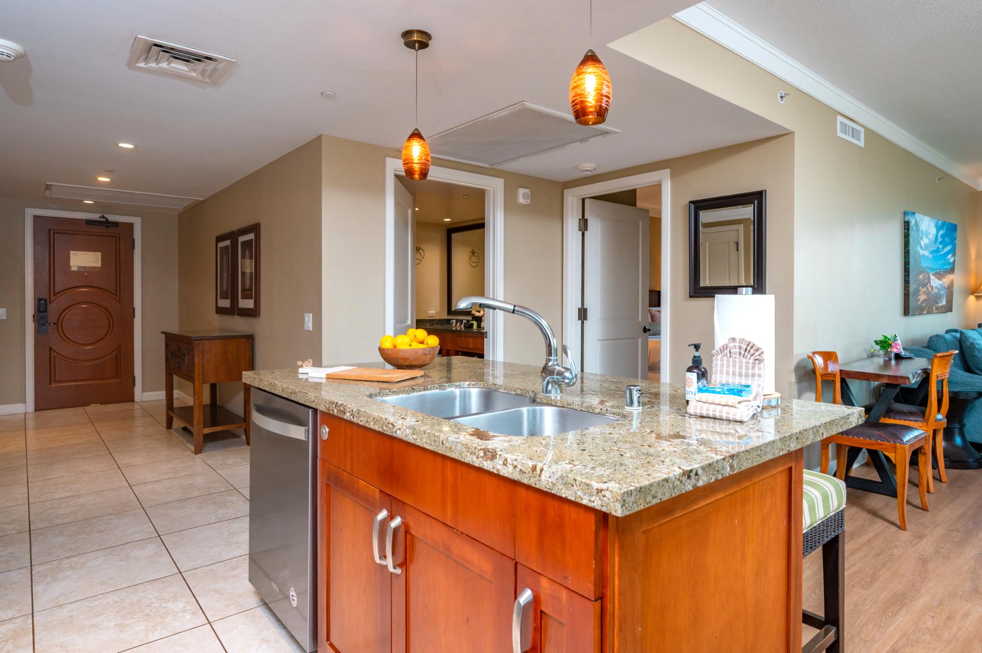 The kitchen island doubles as a prep space and breakfast bar, anchoring the open layout with easy flow to the living and dining areas.