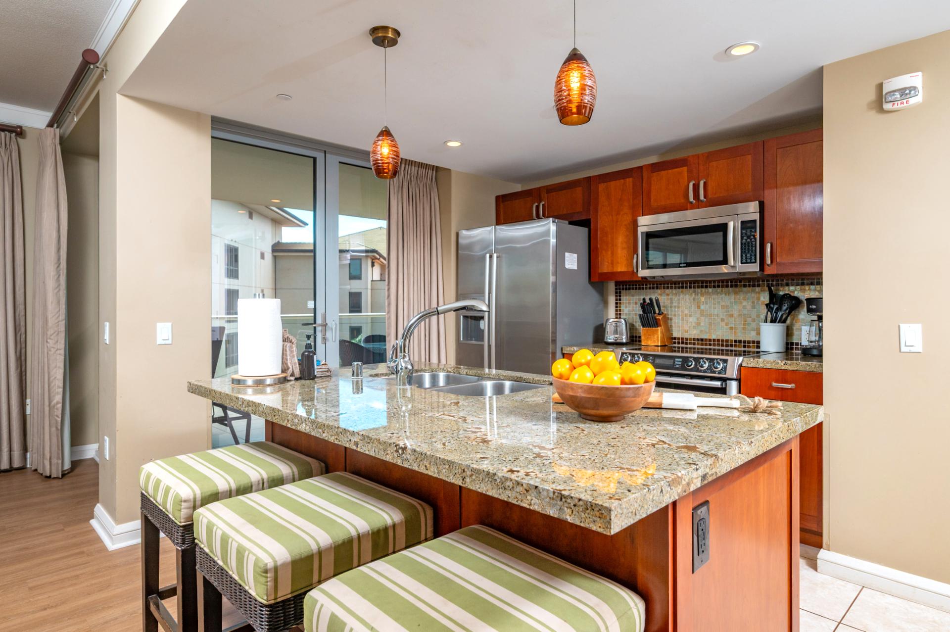 Granite countertops, stainless steel appliances, and island seating make this fully equipped kitchen a welcoming space for prepping tropical breakfasts or cocktails.