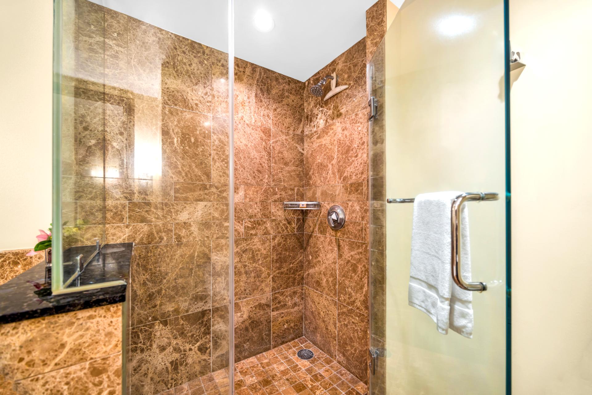 This walk-in shower with granite tile and glass enclosure offers a refreshing rinse after the pool or beach.