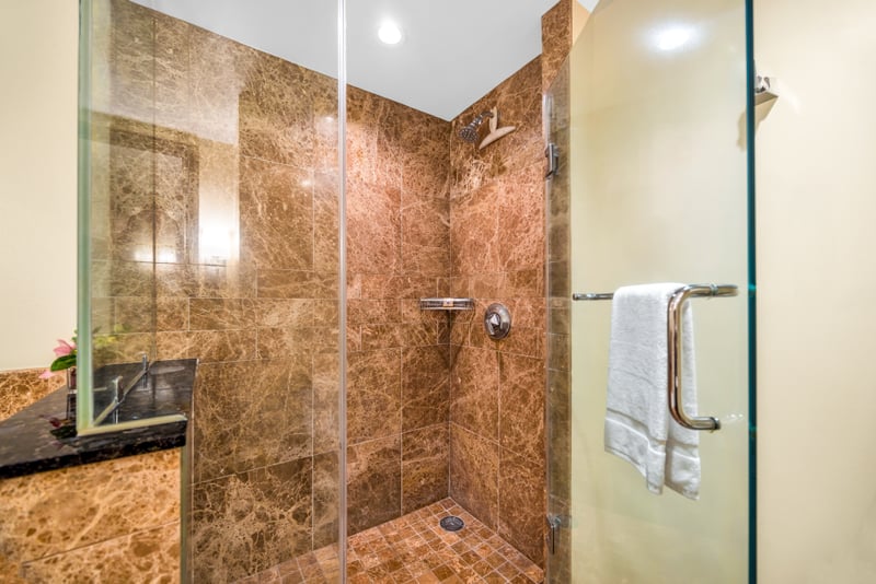 This walk-in shower with granite tile and glass enclosure offers a refreshing rinse after the pool or beach.