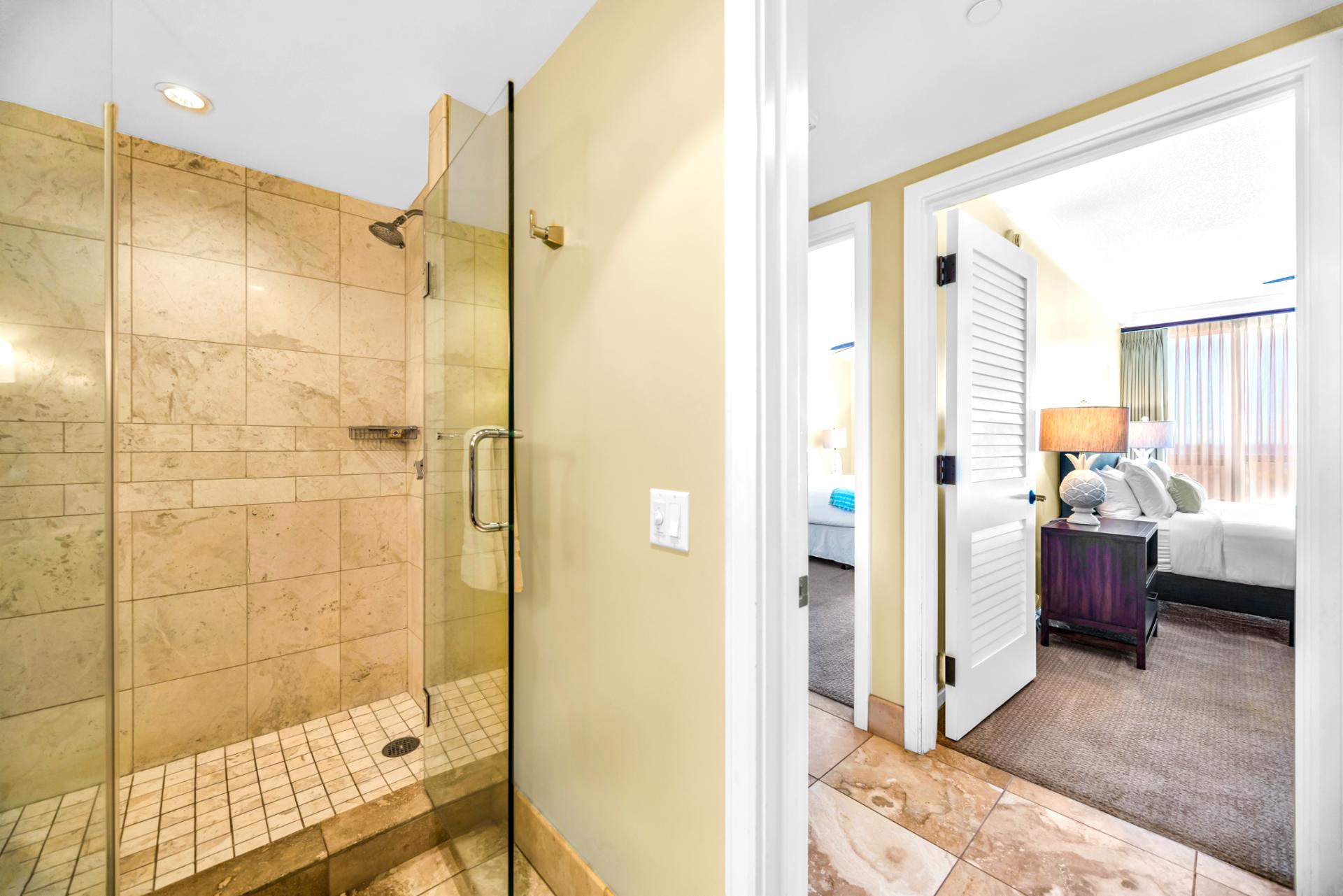 This guest bath features a spacious glass walk-in shower with tile surround and easy hallway access.