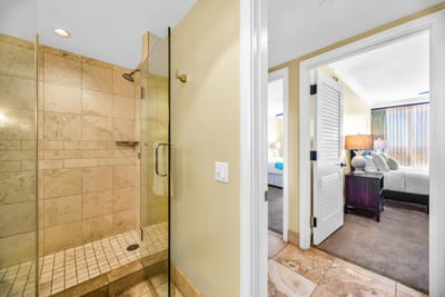 This guest bath features a spacious glass walk-in shower with tile surround and easy hallway access.