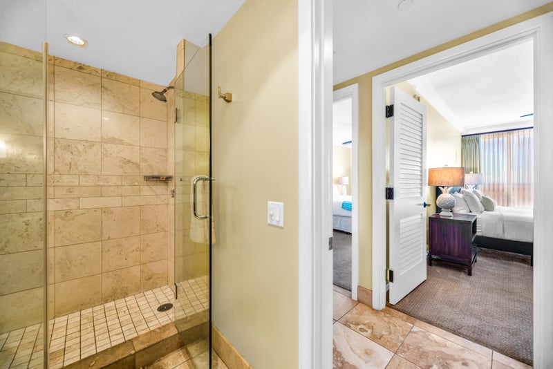 This guest bath features a spacious glass walk-in shower with tile surround and easy hallway access.