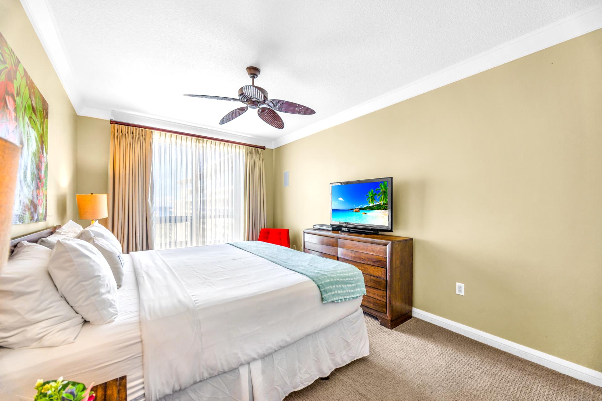 The guest bedroom includes a Queen bed, dresser, and TV, perfect for winding down after your day in the sun.