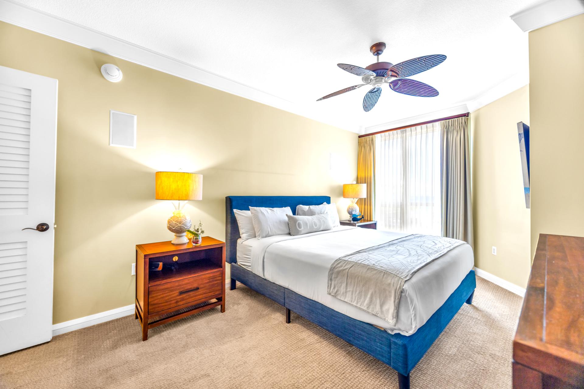 Guest Bedroom 1 features a King bed, warm lighting, and a ceiling fan, comfortable and quiet after sunset strolls.