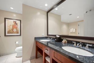 Elegant bathroom with double vanity, granite countertops, and tasteful island decor. HKH-545