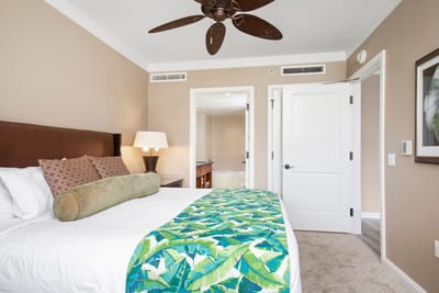 Vibrant tropical bedding highlights bright bedroom with ensuite spa-style bathroom. HKH-545